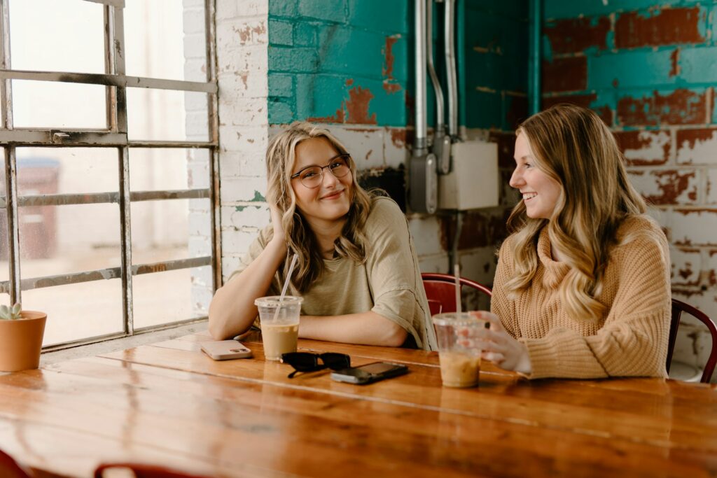 Two women having a conversation in a cafe.