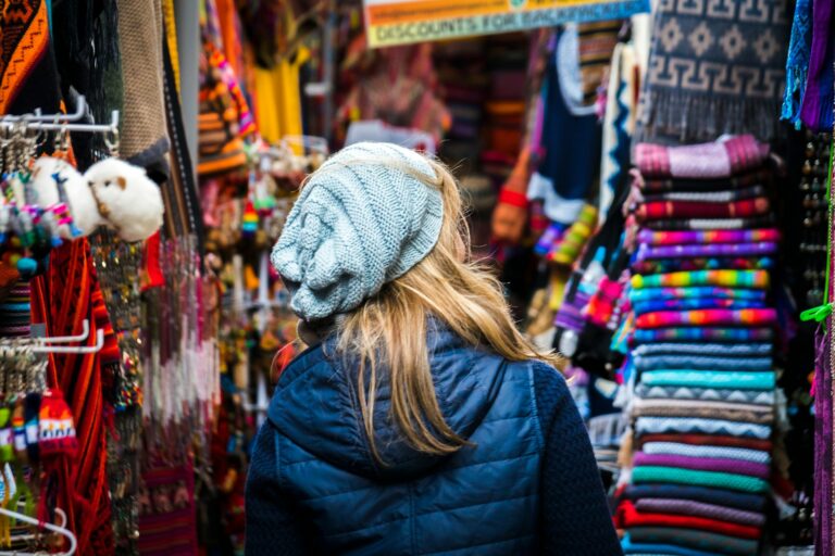 Woman walking through a colorful market.